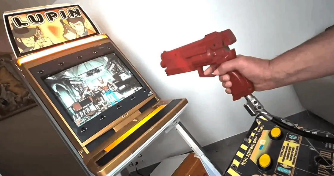 A player aiming a light gun at the screen of a JVS cabinet