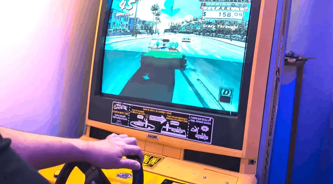 A player at the wheel of a racing cabinet